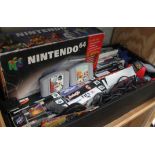 A box containing a boxed Nintendo 64 console, three controllers, various games etc.