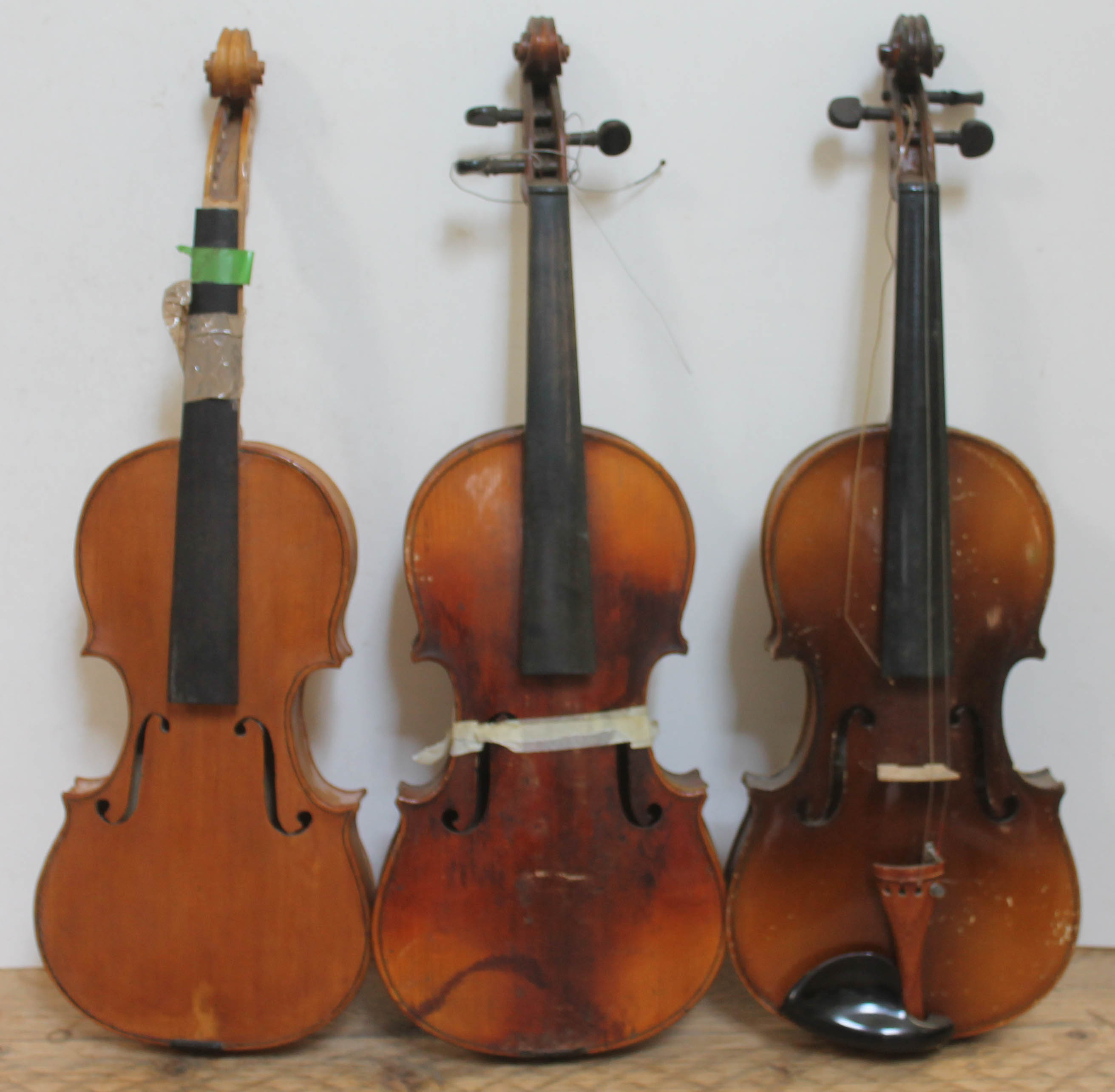 A group of three violins, spares and repairs.