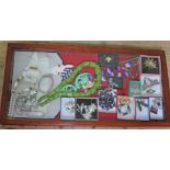 A wooden glazed display tray containing various costume jewellery to include silver, Nina Ricci,