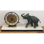 An Art Deco mantle clock with mounted spelter elephant, length 50cm.