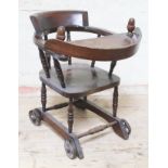 An Edwardian child's chair with wheels and tray.