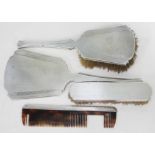 A four piece hallmarked silver dressing table set comprising hand mirror, hand brush, another