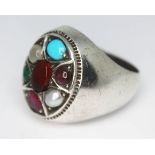 A contemporary multi gemstone ring set with a central amber cabochon and surround by moonstone,