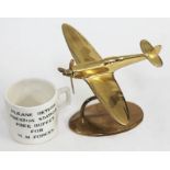 A reproduction brass spitfire on stand and a Preston railway station H.M. Forces pottery mug.