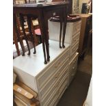 Four items of furniture comprising white chest of drawers with matching bedside, another white