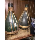 A pair of wicker bound green glass flagons Catalogue only, live bidding available via our website.