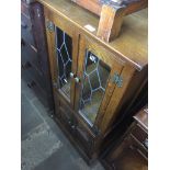 An oak cabinet with leaded glass door Catalogue only, live bidding available via our website. If you