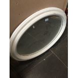 An oval mirror. Catalogue only, live bidding available via our website. Please note we can only
