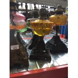 A group of five Victorian oil lamps with cast metal bases and glass reservoirs, heights 29cm - 33cm.