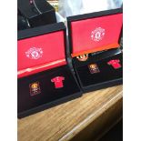 A pair of cased Mnchester United Vs Arsenal 210/11 badges Catalogue only, live bidding available via