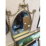 An ornate gilt framed oval mirror. Catalogue only, live bidding available via our website. Please