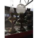 An oil lamp with shade and funnel and an electric lamp with funnel. Catalogue only, live bidding