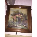 An early 20th century school floral garden scene, oil on board, indistinctly signed lower left, 38cm