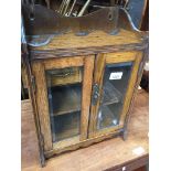 An Edwardian oak smoker's cabinet with bevelled glass doors. Catalogue only, live bidding
