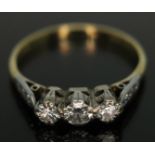 A three stone diamond ring, the central stone weighing approx. 0.15 carats, diamond set shoulders,