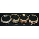 A group of four rings comprising a hallmarked 18ct white gold seven colourless stone ring, two