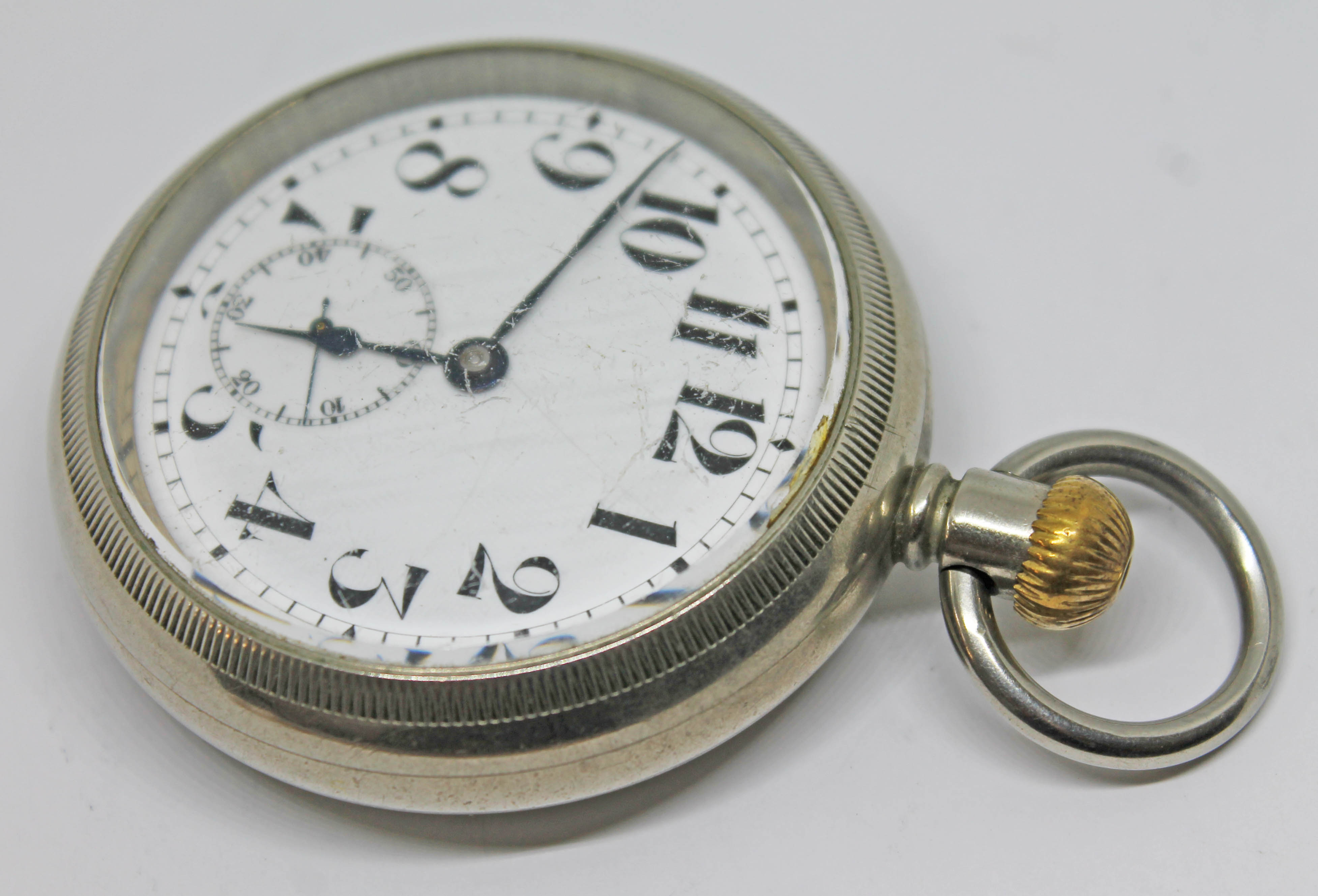 A Cyma open face pocket watch with large Arabic numerals on a white enamel dial and seconds