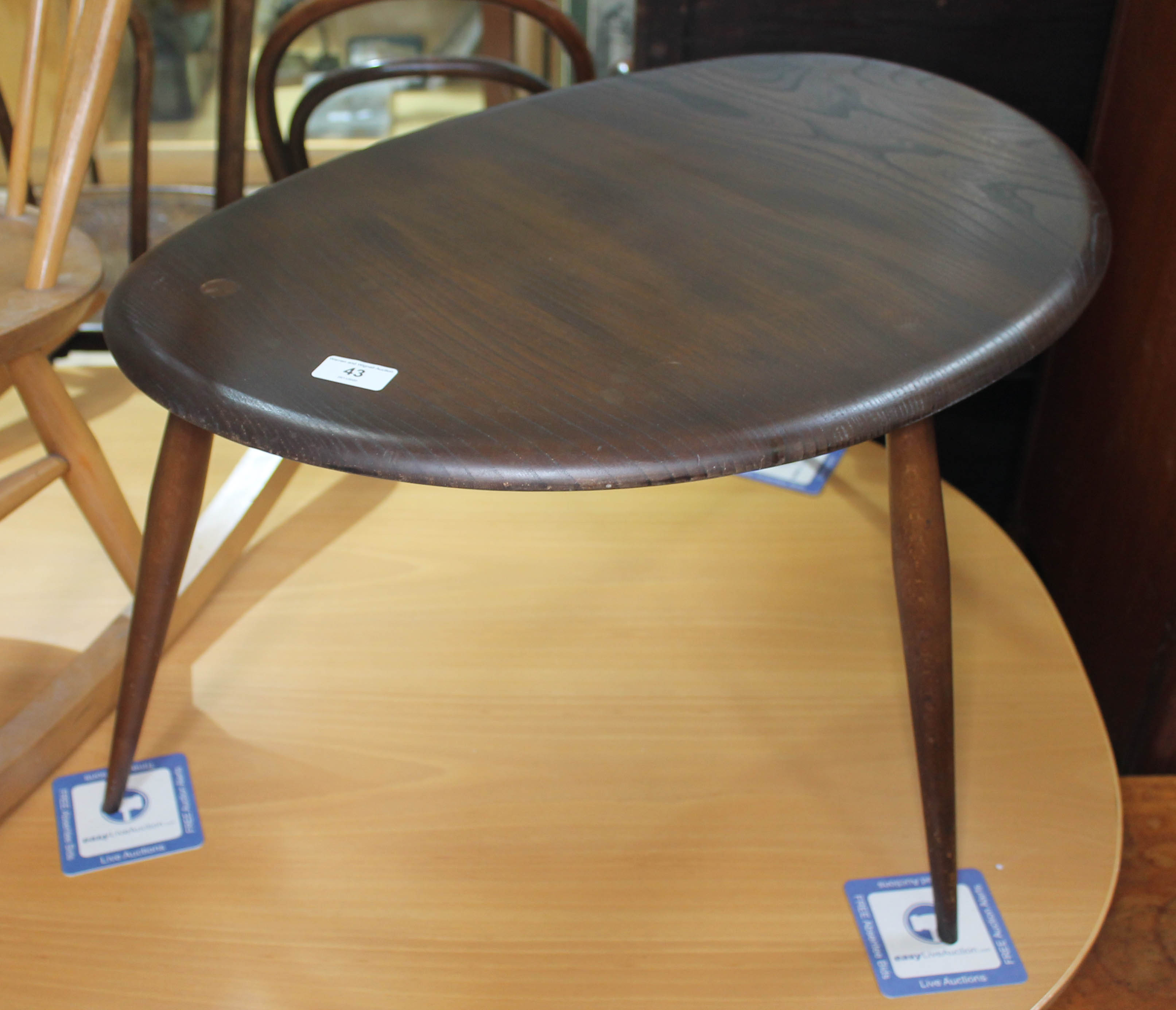 A dark elm Ercol single pebble table, height 40cm, width 66cm. Condition: no signs of any damage,