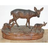 A finely carved Black Forest wood sculpture depicting three deer on naturalistically formed base,