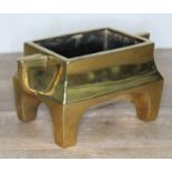 A Chinese bronze twin handled censer or incense burner of rectangular form with square section legs