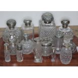 A group of fourteen hallmarked silver topped or mounted glass bottles and jars, tallest 14cm.