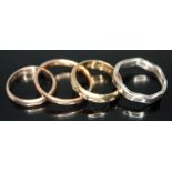 A group of four rings comprising two hallmarked 9ct gold wedding bands, a hallmarked 9ct gold