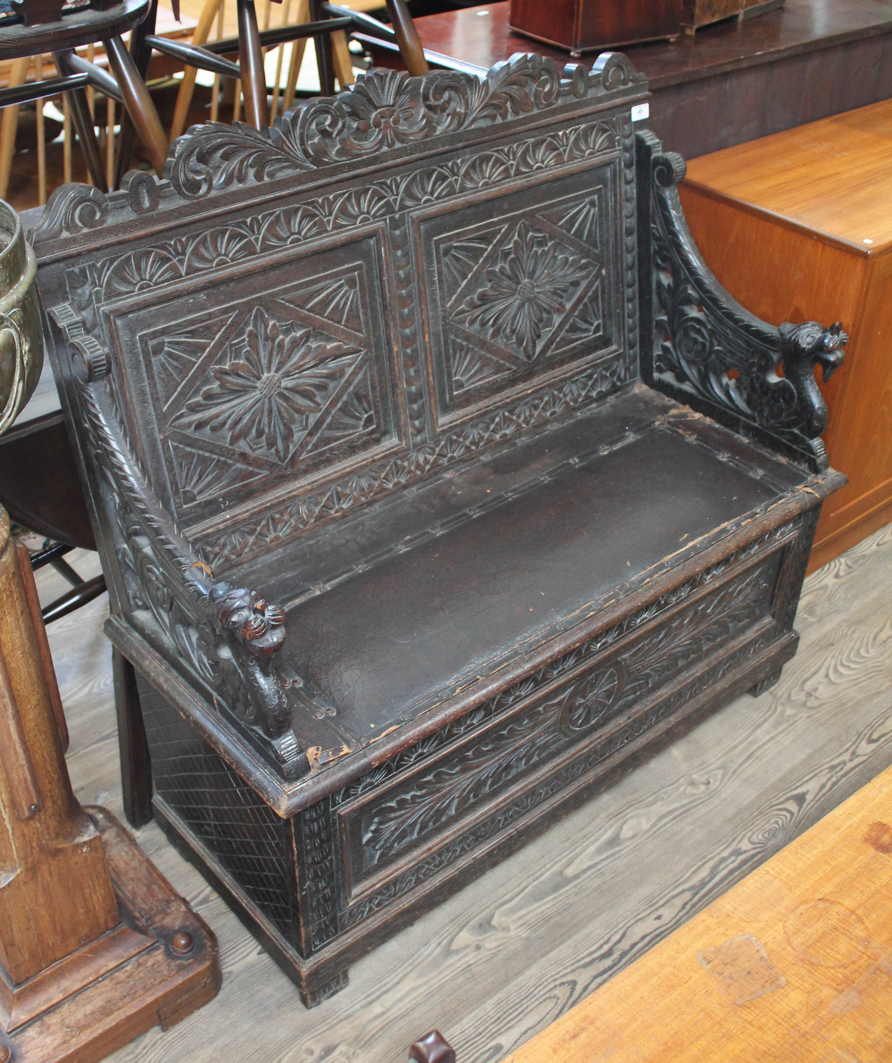 A 19th century carved oak small settle with carved dragon arms, height 104cm, length 107cm, depth