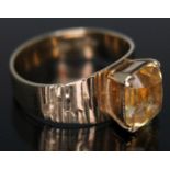 A modernist ring set with a cushion cut citrine, band marked '9ct', gross wt. 3.56g, size N.