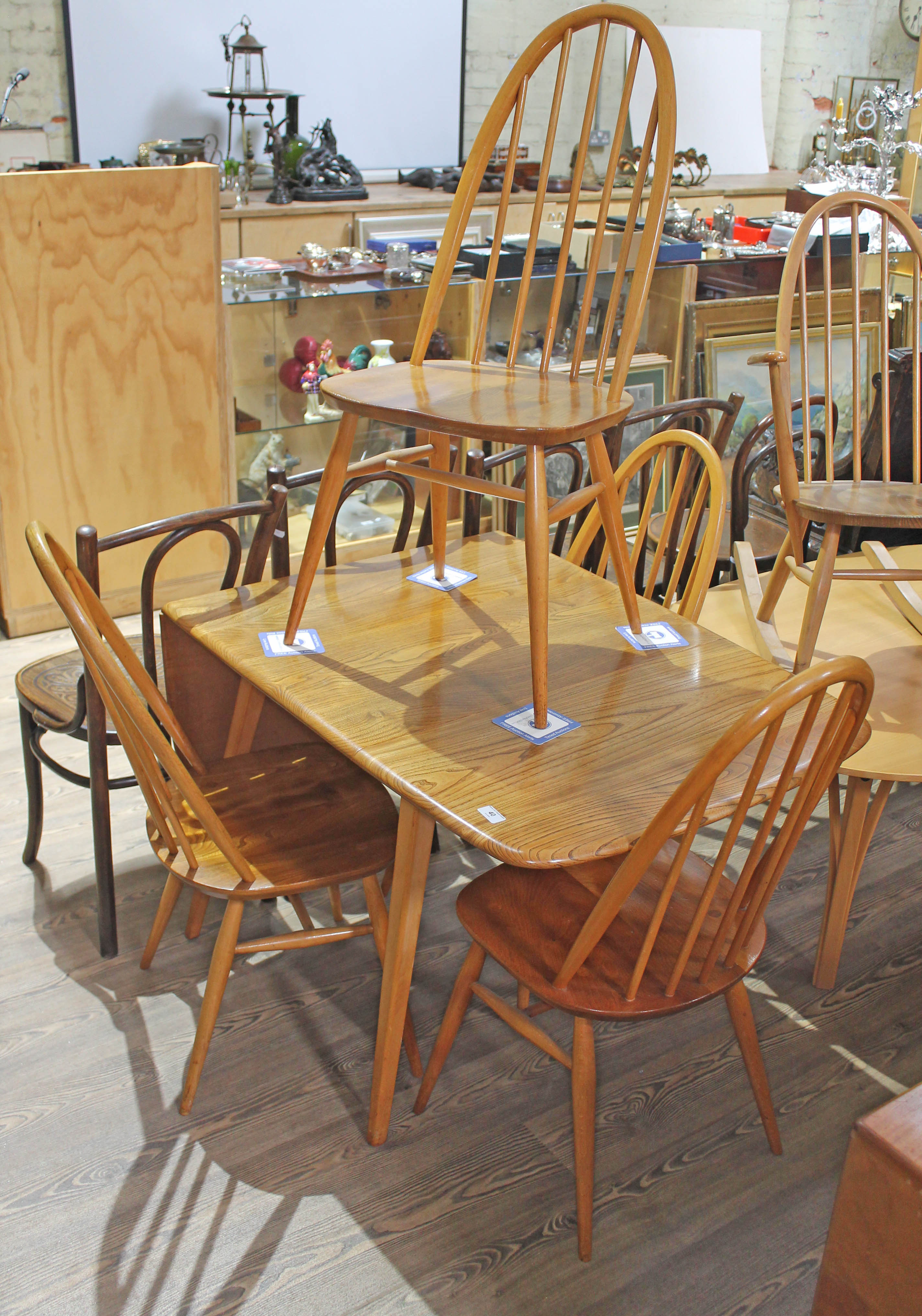 An Ercol blonde elm drop leaf table and four spindle back chairs, max length 138cm, width 74cm.