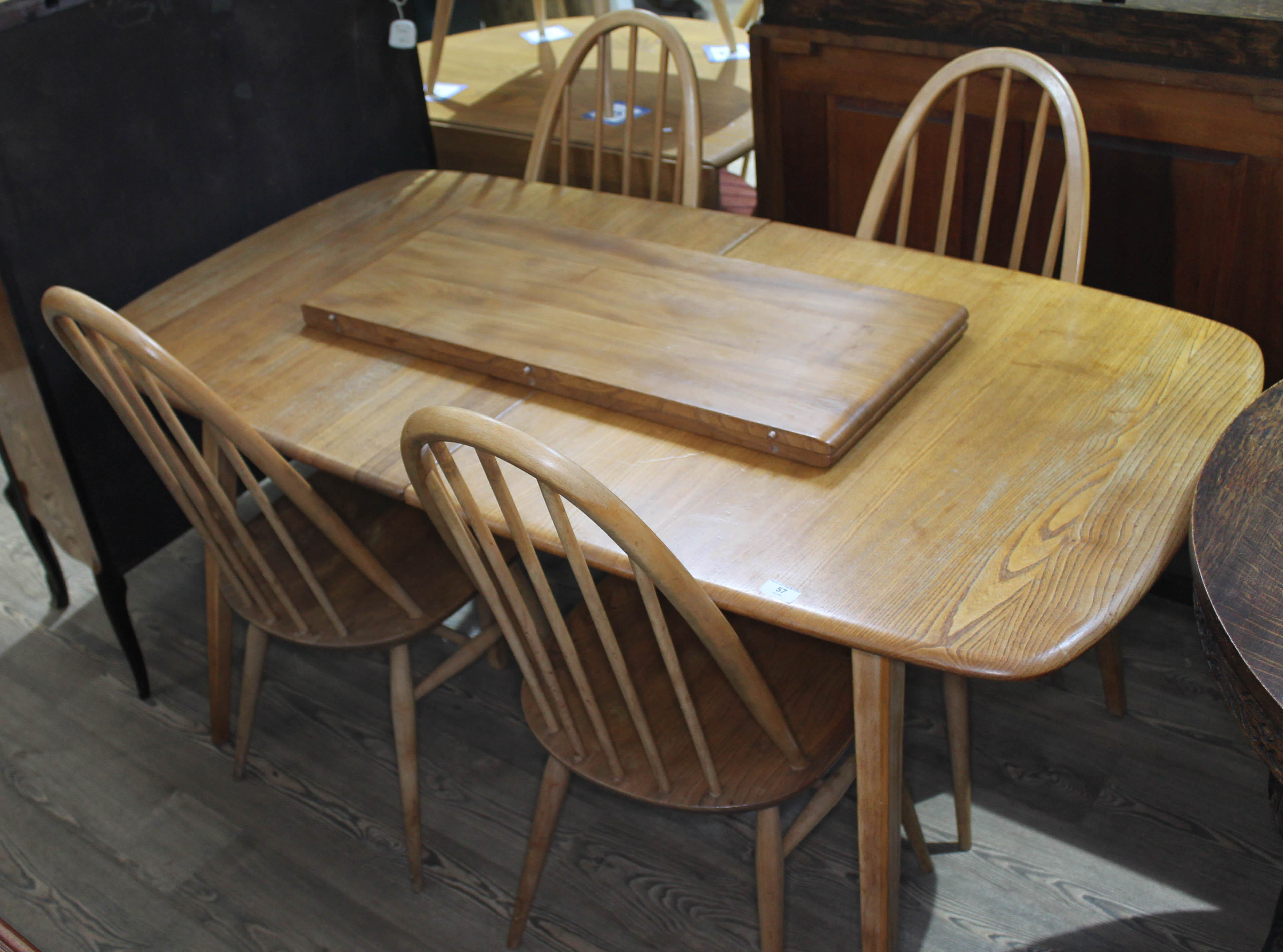 An Ercol blonde elm extending dining table and four spindle back chairs, max. table length 227cm,