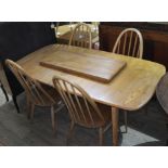An Ercol blonde elm extending dining table and four spindle back chairs, max. table length 227cm,