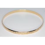 A hallmarked 9ct gold engraved bangle, diam. 67mm, wt. 10.09g. Condition - good, no damage/repair,