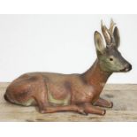 A large terracotta figure depicting a seated deer, length 43cm. Condition - one antler broken off