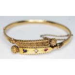 A Victorian diamond, ruby and sapphire set bangle, diam. approx. 55mm, unmarked, wt. 10.96g.