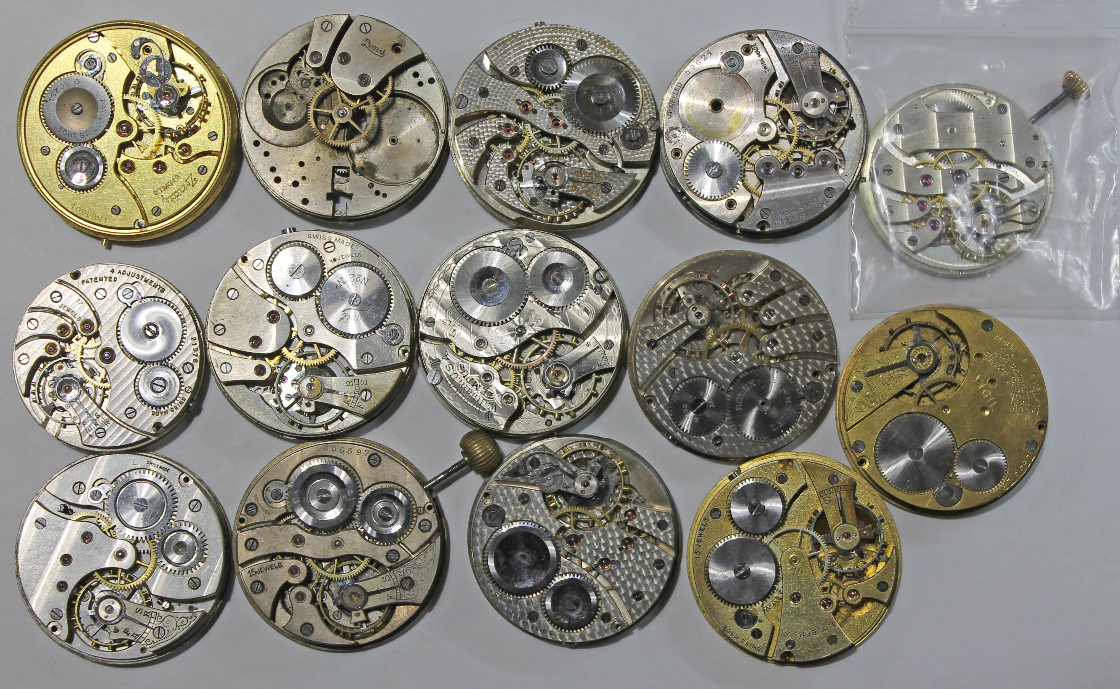 A collection of 14 pocket watch movements, some with dials and crowns, including a Birks 'Broker',