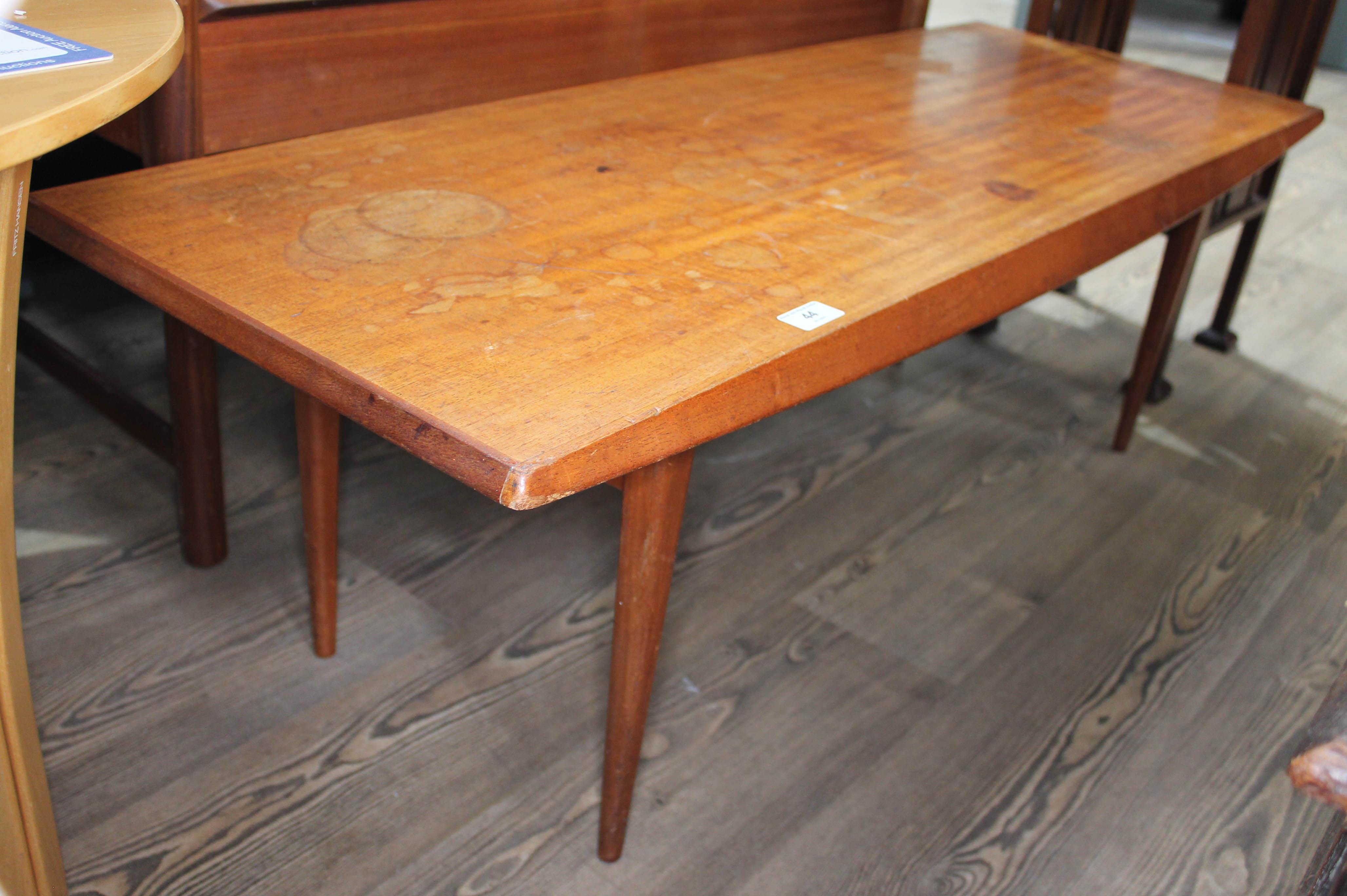 A Gordon Russell teak long coffee table on tapered legs, height 40cm length 121cm. Condition: cup