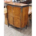 A French serpentine kingwood marquetry inlaid drinks cabinet with gilt metal mounts and floral