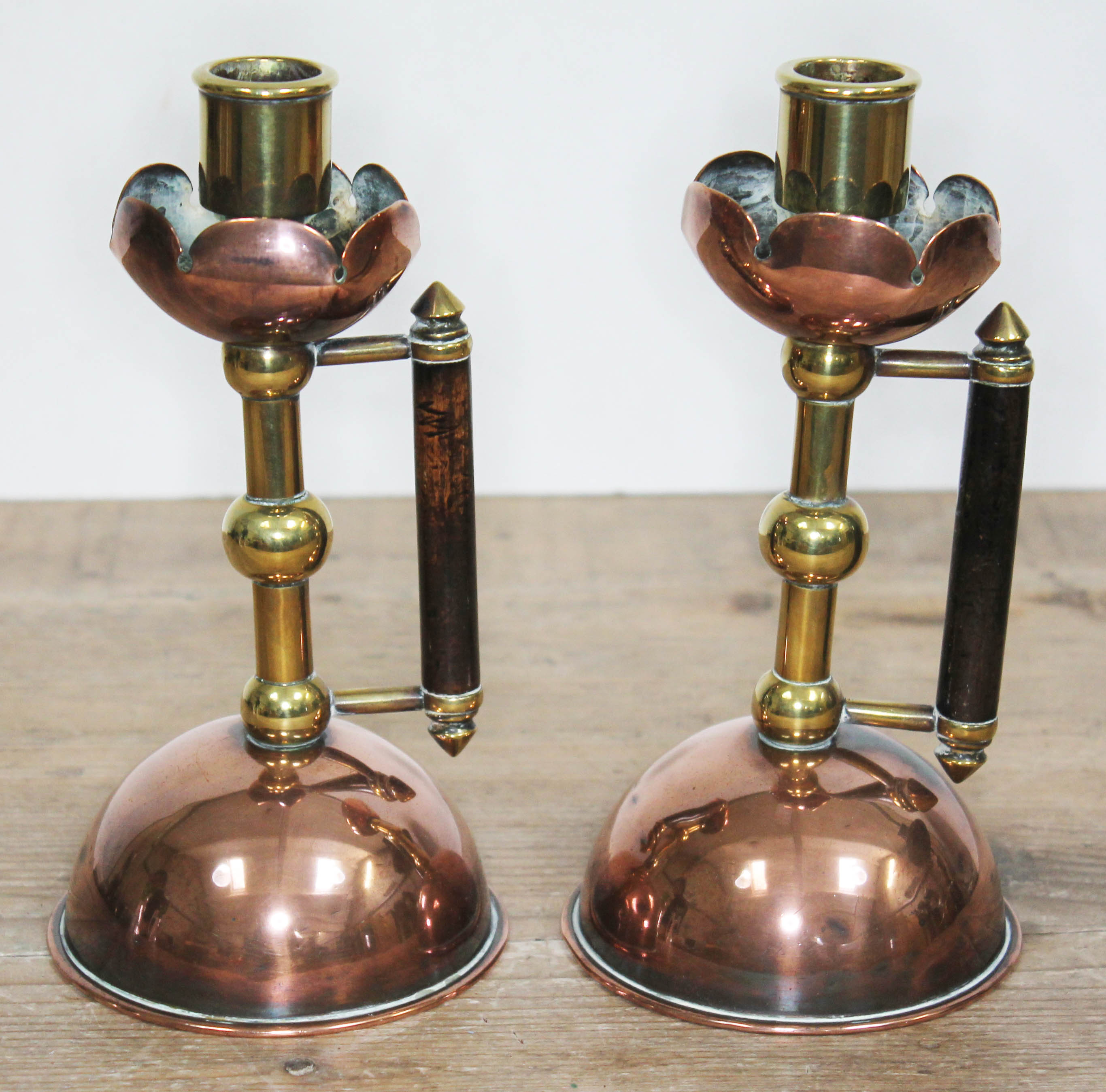 A pair of Arts & Crafts copper and brass candlesticks, manner of Christopher Dresser/Benham & Froud,