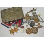 A WWI Christmas tin and contents including three WWII medals, badges etc.