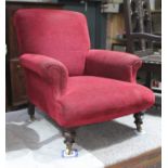 A late Victorian upholstered low armchair in the manner of Howard & Sons, with scrolled back and