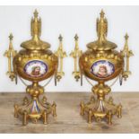 A pair of ormolu and porcelain urns, architectural style with finials, handles and bows, each with a