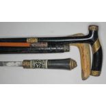 Two walking canes including horn handled and yellow metal mounted, an Indian shooting stick with