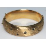 A hallmarked 9ct gold bangle set with blue stones, diam. approx. 56mm, gross wt. 33.35g. Condition -