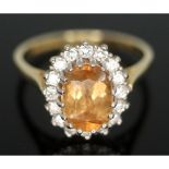 A citrine and diamond cluster ring, the central stone measuring approx. 8mm x 5mm x 2mm, surrouned