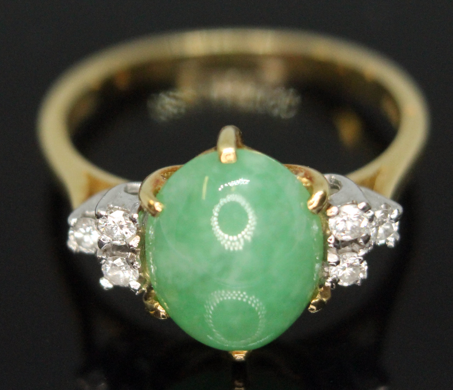 A diamond and jade cabochon ring, the central jadeite jade cabochon measuring approx. 9mm x 8mm x