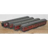 A group of four Exley 0 gauge maroon carriages.