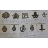 A group of ten cap badges.