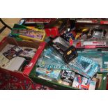 4 boxes (under table) of model cars etc, mostly boxed, including Burago, Corgi, Maisto, and also a