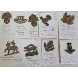 A group of nine cap badges including Irish.