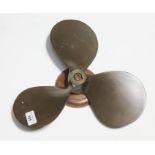 A bronze propeller on wooden plinth, each blade approx 7" long